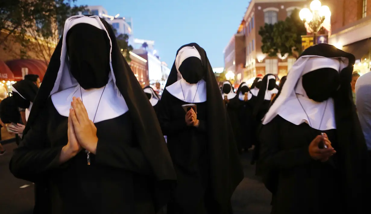 Wanita berpakaian biarawati berjalan sambil mempromosikan film 'The Nun' di luar San Diego Comic-Con, San Diego, California, Amerika Serikat, Kamis (19/7). (Mario Tama/Getty Images/AFP)