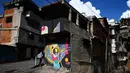 Warna-warni mural menghiasi tembok di permukiman kumuh Petare di Caracas pada 29 Mei 2019. Petare yang merupakan kawasan kumuh terbesar di Venezuela menjadi rumah bagi lebih dari 500.000 jiwa. (Photo by MARVIN RECINOS / AFP)