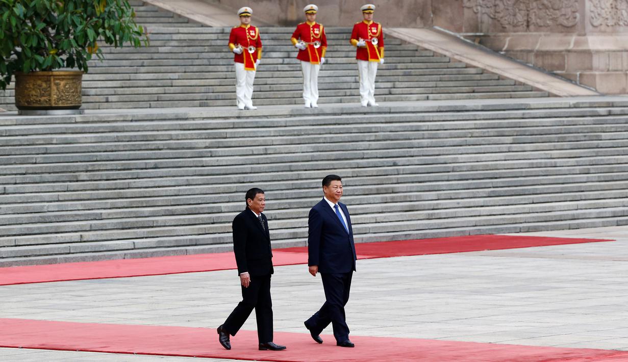 Presiden Filipina Rodrigo Duterte dan Presiden China Xi Jinping berjalan untuk menghadiri upacara penyambutan di Balai Agung Rakyat di Beijing, Tiongkok (20/10). Kedatangan Duterte untuk memperat hubungan bilateral dengan Tiongkok. (Reuters/Thomas Peter)