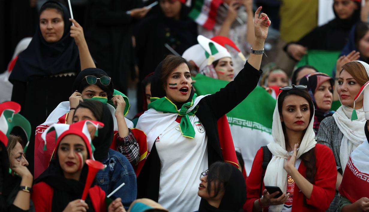 Perawat Iran Zahra Pashaei (tengah) bersorak saat menyaksikan laga kualifikasi Piala Dunia 2022 antara Iran dengan Kamboja di Stadion Azadi, Teheran, Iran, Kamis (10/10/2019). Pihak penyelenggara menyediakan tempat khusus di tribune untuk suporter wanita. (AP Photo/Vahid Salemi)
