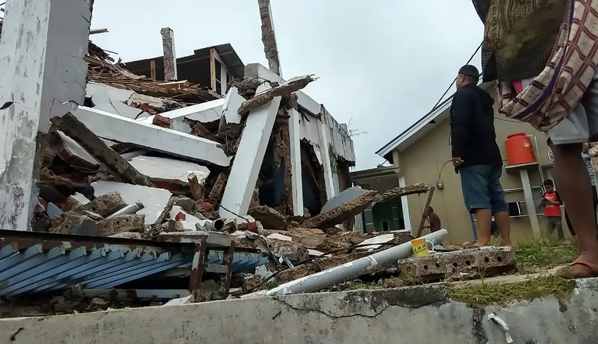 Penduduk desa memeriksa rumah mereka yang rusak setelah gempa magnitudo 5,1  di Sukabumi, Jawa Barat (10/3/2020). Menurut BMKG pusat gempa berada pada koordinat 6.81 LS dan 106.66 BT. (AFP/Handout/BNPB)