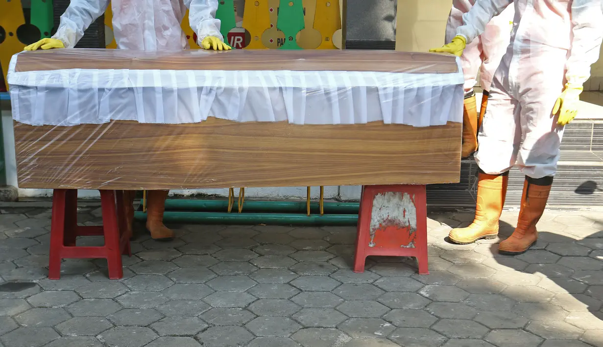 Petugas gabungan dari Kecamatan Cilandak bersiap mengarak instalasi peti mati jenazah Covid-19 di kantor Kecamatan Cilandak, Jakarta, Jumat (28/8/2020). Sosialisasi tersebut dilakukan untuk memberikan peringatan kepada warga akan bahaya penularan virus Covid-19. (Liputan6.com/Herman Zakharia)
