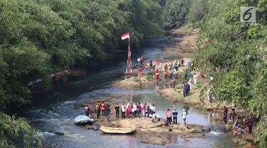 Komunitas Ciliwung Depok mengikuti upacara bendera di Sungai Ciliwung, Jawa Barat, Jumat (17/8). Upacara di tengah aliran Sungai Ciliwung tersebut dalam rangka memperingati HUT ke-73 Republik Indonesia. (Liputan6.com/Immanuel Antonius)