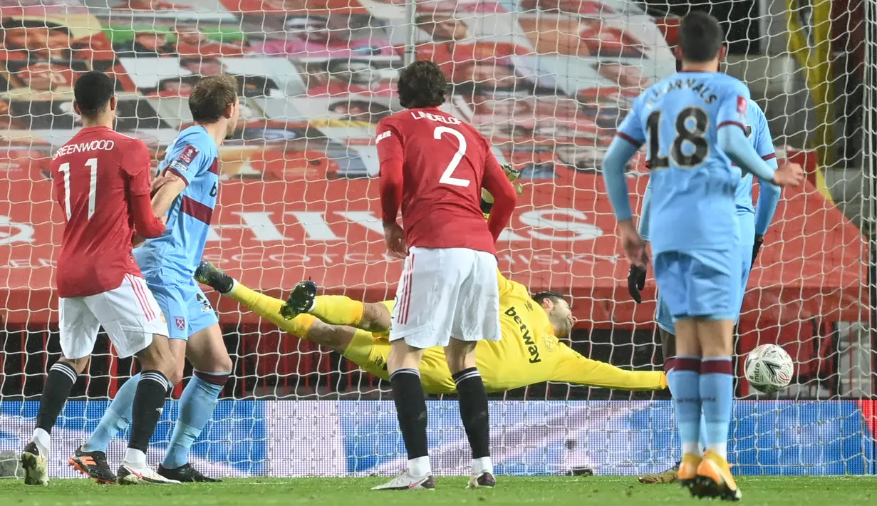 Kiper West Ham United, Lukasz Fabianski melakukan penyelamatan dalam laga babak kelima Piala FA 2020/21 melawan Manchester United di Old Trafford Stadium, Selasa (9/2/2021). West Ham kalah 0-1 (0-0) dari Manchester United melalui extra time. (AFP/Michael Regan/Pool)