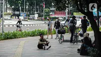 Sejumlah warga beraktivitas di Bundaran HI, Jakarta, Minggu (2/1/2022). Meski hari bebas kendaraan bermotor atau car free day (CFD) ditiadakan, warga masih banyak yang beraktivitas di kawasan Sudirman-Thamrin. (Liputan6.com/Faizal Fanani)