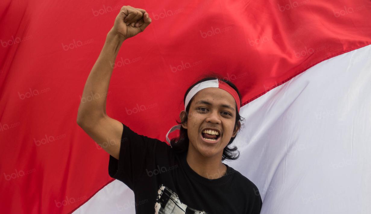 Dengan penuh semangat seorang suporter bernyanyi mendukung Timnas Indonesia yang akan bertanding melawan Vietnam di Stadion Pakansari, Jawa Barat, Sabtu (3/12/2016). (Bola.com/Vitalis Yogi Trisna)