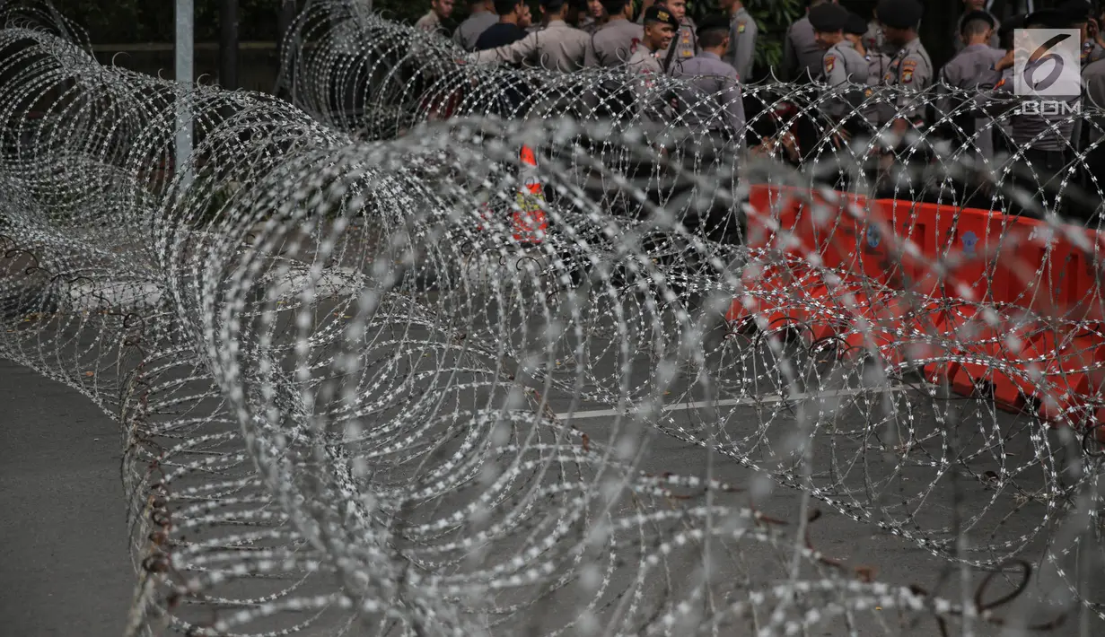 Kawat berduri dua lapis dipasang di depan Kedutaan Besar Myanmar, Jakarta, Rabu (6/9).  Jelang aksi kedubes Myanmar dikelilingi oleh kawat berduri dan dijaga polisi bersenjata lengkap serta kendaraan taktis water cannon. (Liputan6.com/Faizal Fanani)