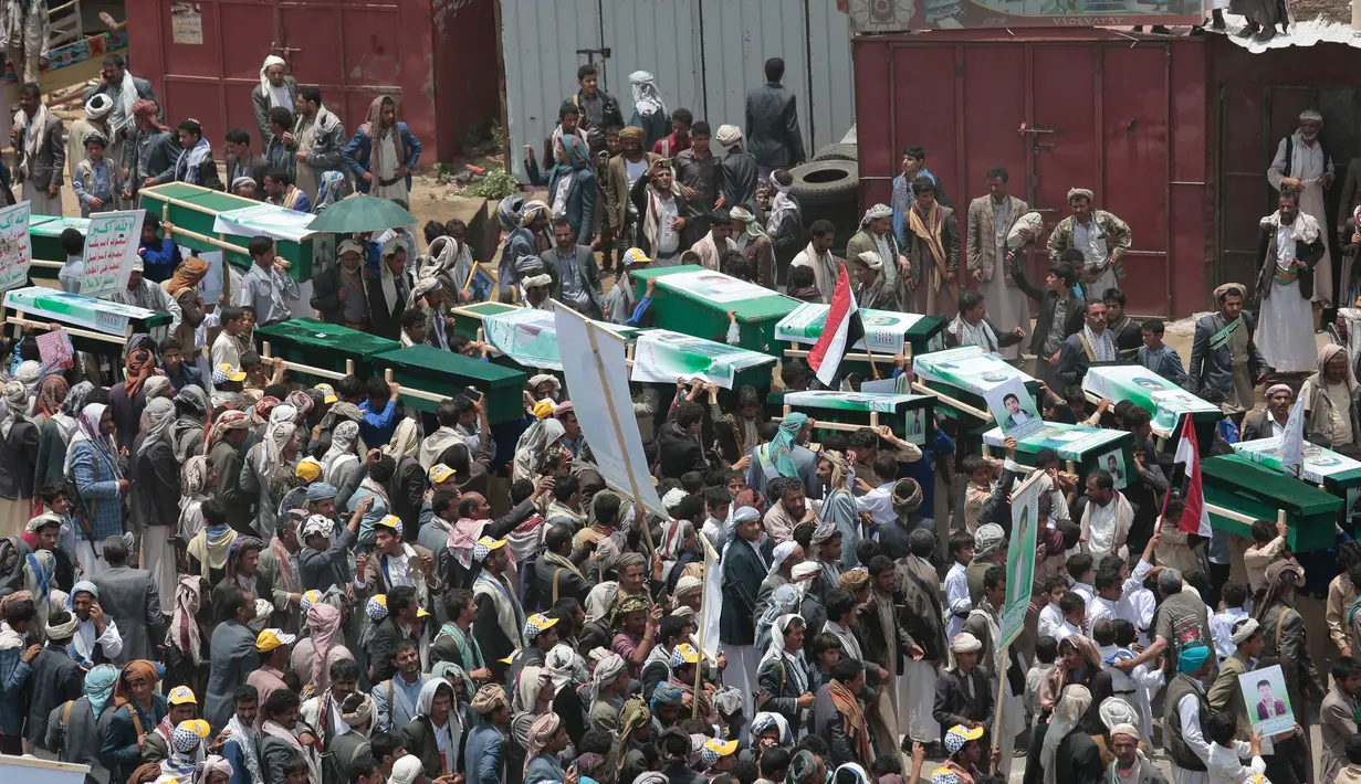 Orang-orang membawa peti jenazah puluhan bocah di Yaman korban serangan koalisi Arab Saudi, pada pemakaman di Saada, Senin (13/8). Pemakaman diwarnai protes terhadap Saudi yang dinilai bertanggung jawab atas kematian anak-anak tersebut. (AP/Hani Mohammed)