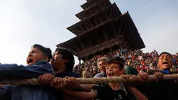 Sejumlah umat Hindu Nepal menarik kereta kayu dewa Bhairava saat festival Bisket Jatra di Bhaktapur, Nepal (10/4). Mereka menarik kereta kayu yang membawa dewa Hindu Bhairava ke lapangan terbuka. (AP Photo/Niranjan Shrestha)
