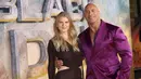 Dwayne Johnson (kanan) dan Ella Craig berpose untuk fotografer saat tiba pada pemutaran perdana film 'Black Adam' di London, Inggris, 18 Oktober 2022. Dwayne Johnson tampak hangat dengan Ella Loudon yang merupakan putri aktris Daniel Craig. (Photo by Vianney Le Caer/Invision/AP)