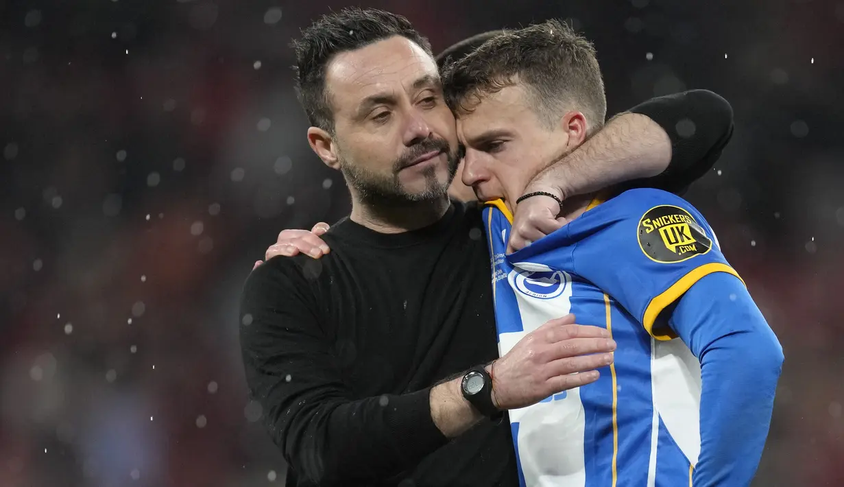 Pelatih kepala Brighton, Roberto De Zerbi (kiri) memberikan pelukan kepada pemainnya, Solly March setelah gagal mengeksekusi tendangan penalti pada laga semifinal Piala FA 2022/2023 di Stadion Wembley, London, Minggu (23/04/2023). Laga dimenangkan oleh MU dengan skor 7-6. (AP Photo/Kirsty Wigglesworth)