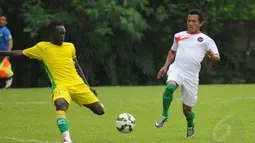 Gelandang Timnas U-23 Indonesia, Hendra Bayauw (kanan) berebut bola dengan salah satu pemain asing saat berlatih tanding di POR Sawangan, Depok, Rabu (31/12/2014). (Liputan6.com/Helmi Fithriansyah)