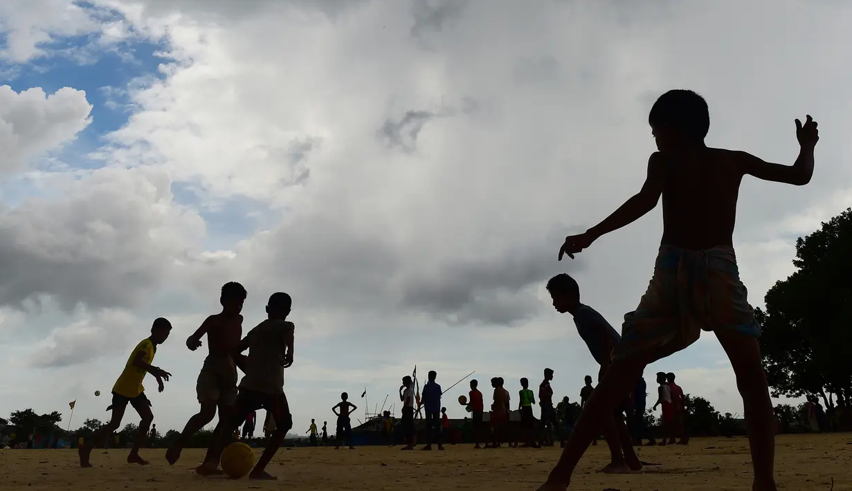 Anak-anak Rohingya bermain sepak bola di kamp pengungsi Kutupalong di Ukhia, Bangladesh, 19 Juli 2018. Bendera Argentina dan Brasil bahkan masih berkibar berdampingan dengan bendera Bangladesh di kamp pengungsi terbesar di dunia. (AFP/Munir UZ ZAMAN)
