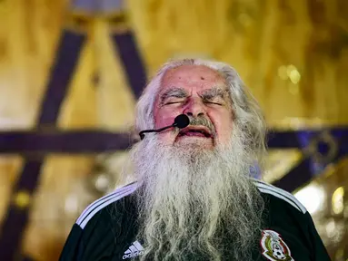Peramal asal Meksiko, Antonio Vazquez, membaca mantra saat melakukan ritual di Meksiko City, Rabu (13/6/2018). Ritual tersebut dilakukan agar Timnas Meksiko sukses di Piala Dunia 2018. (AFP/Ronaldo Schemidt)
