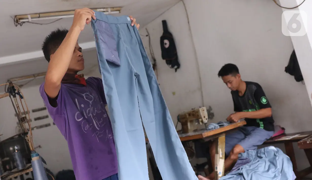 Para pekerja menyelesaikan pembuatan seragam sekolah di usaha konveksi skala rumah tangga Kebayoran Lama, Jakarta, Kamis (9/7/2020). Pandemi virus corona COVID-19 berdampak pada sepinya pesanan pembuatan seragam sekolah. (Liputan6.com/Angga Yuniar)