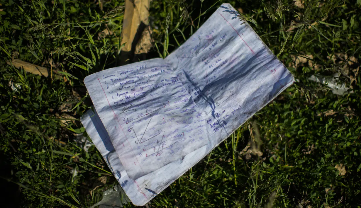 <p>Sebuah buku catatan siswa tergeletak di tanah di samping sebuah sekolah yang hancur dalam pemboman Rusia di Bakhmut, Ukraina timur, Selasa (24/5/2022). Kota Bakhmut telah mengalami peningkatan serangan artileri, terutama selama seminggu terakhir, ketika pasukan Rusia mencoba untuk terus maju mengepung kota Sieverodonetsk di timur laut. (AP Photo/Francisco Seco)</p>