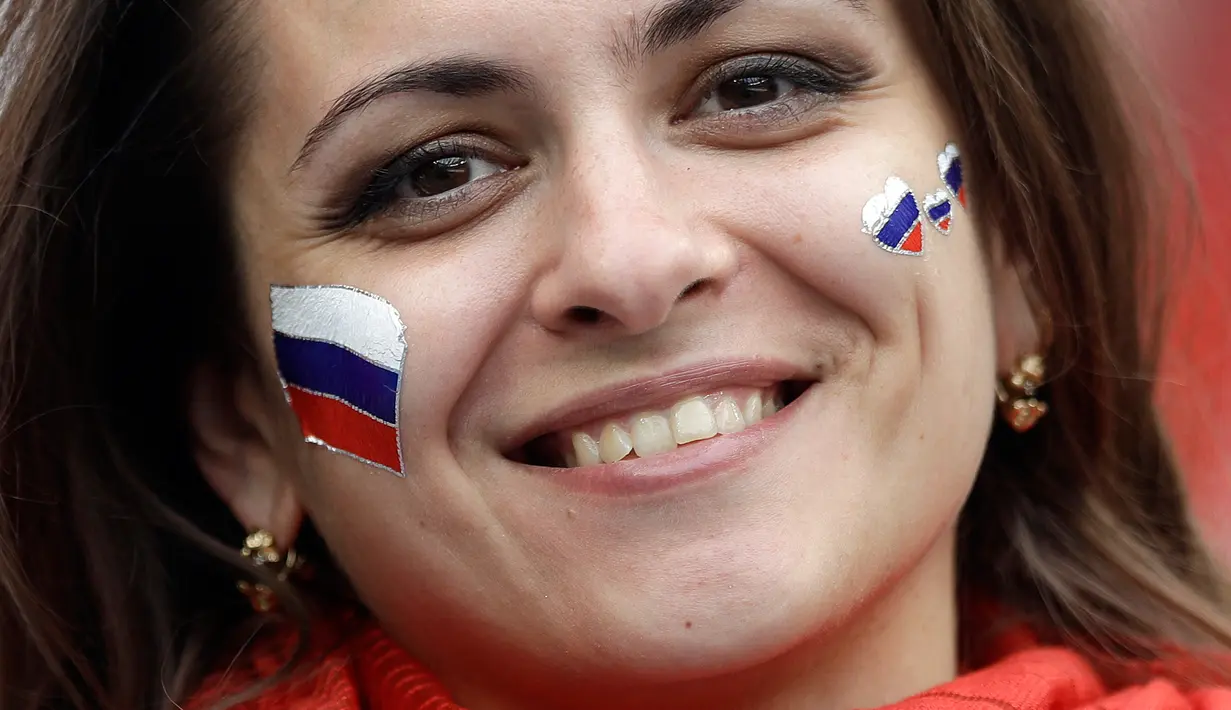 Suporter wanita tersenyum sebelum pertandingan grup A Piala Dunia 2018 antara Rusia dan Arab Saudi di stadion Luzhniki di Moskow, (14/6). Dalam pertandingan ini, Rusia menang 5-0 atas Arab Saudi. (AP Photo/ Matthias Schrader)