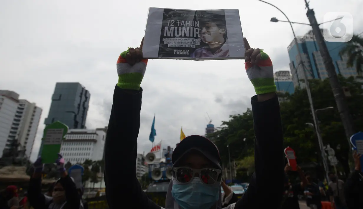 Aktivis membawa poster bergambar Munir saat berunjuk rasa memperingati Hari HAM Sedunia di Patung Kuda, Jakarta, Kamis (10/12/2020). Pada Hari HAM Sedunia 2020, diharapkan mampu mengatasi kegagalan yang diekspos dan dieksploitasi oleh COVID-19. (merdeka.com/Imam Buhori)