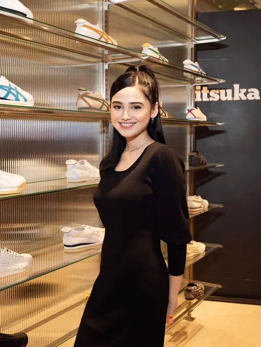 Ia mengenakan long sleeve midi dress hitam polos dan sneakers putih [@syifahadju]