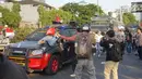 Massa pelajar menyerang kendaraan milik kepolisian yang melintas saat aksi unjuk rasa  di sekitar kawasan DPR RI, Jakarta, Senin (30/9/2019). Sempat terjadi kericuhan akibat peristiwa tersebut hingga menyebabkan jalan tol ditutup. (Liputan6.com/Immanuel Antonius)