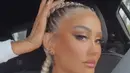 Agnez Mo baru saja menggunggah sebuh video dari Instagram Livenya. Ia tampil dengan makeup glamour dengan riasan mata coral dan eyeliner eings, full lips sehingga nampak bibirnya tebal, dan contouring tebal yang menonjolkan pipinga. Dengan gaya rambut dutch braid di rambut abu-abuanya. @agnezmo