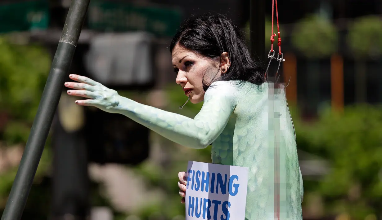 Seorang wanita bernama Victoria Lemeow menggelar aksi menolak penangkapan ikan di Seattle, AS, Senin (5/6). Aksi yang disponsori PETA  ini sebagai protes terhadap SeaWeb Seafood Summit yang diadakan di kawasan tersebut. (AP Photo / Elaine Thompson)