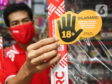 Pekerja toko kelontong “Sampoerna Retail Community (SRC) Barokah” memasang materi sosialisasi Program Pencegahan Akses Pembelian Rokok oleh Anak-anak (PAPRA) di Johar Baru, Jakarta, Senin (16/11/2020). PT HM Sampoerna Tbk sejak 2013 telah memprakarsai sejak tahun 2013. (Liputan6.com/Pool/SRC)