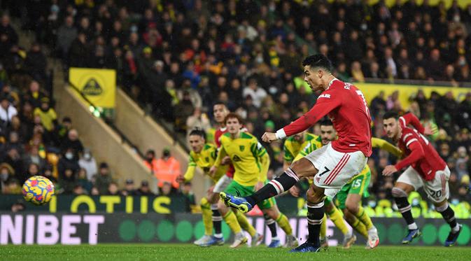 Pemain Manchester United Cristiano Ronaldo mencetak gol ke gawang Norwich City dari titik penalti pada pertandingan sepak bola Liga Inggris di Stadion Carrow Road, Norwich, Inggris, 11 Desember 2021. Manchester United menang 1-0. (Daniel LEAL/AFP)