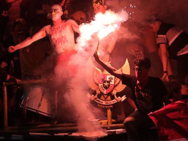 Suporter Timnas Indonesia U-19 menyalakan suar saat laga Grup A Piala AFF U-19 2022 antara Timnas Indonesia U-19 melawan Timnas Vietnam U-19 di Stadion Patriot Candrabhaga, Bekasi, Jawa Barat, Sabtu (02/07/2022). (Bola.com/Ikhwan Yanuar)