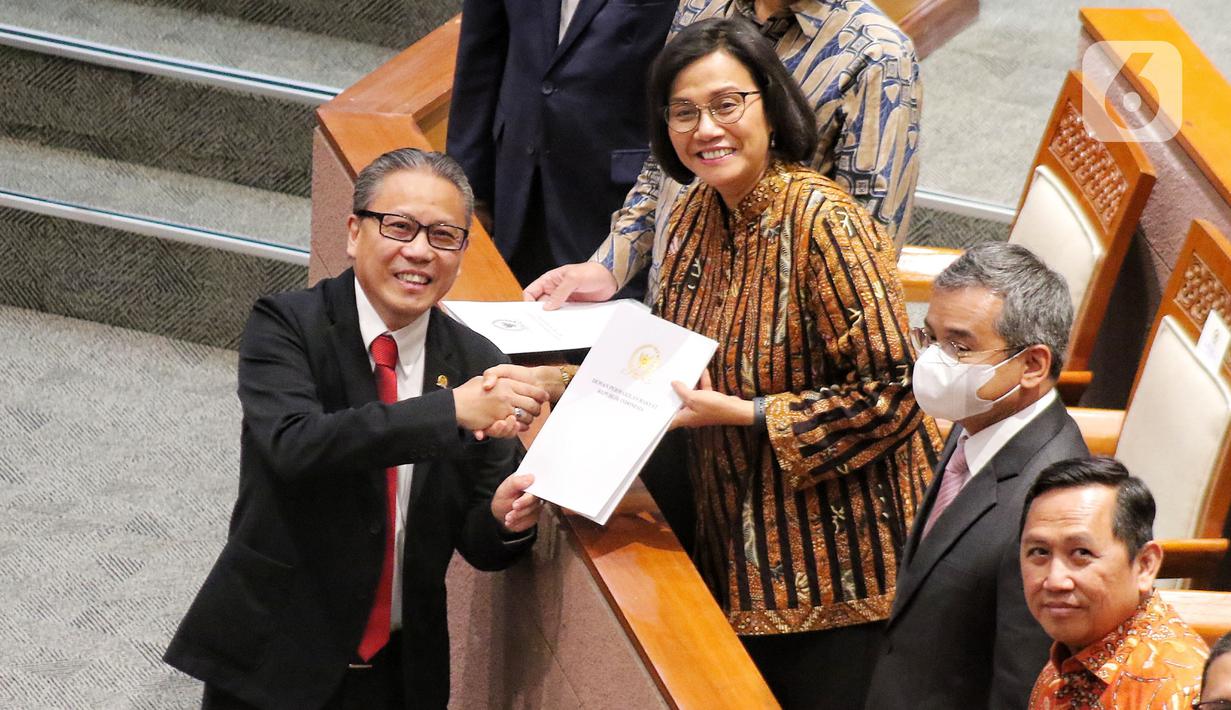 Wakil Ketua Komisi XI DPR RI Dolfie Othniel Frederic Palit menyerahkan hasil pendapat fraksi kepada Menteri Keuangan (Menkeu) Sri Mulyani Indrawati saat rapat Paripurna DPR RI Ke-13 Masa Persidangan II Tahun Sidang 2022-2023 di Kompleks Parlemen, Senayan, Jakarta, Kamis (15/12/2022). DPR menyetujui Rancangan Undang-undang Pengembangan dan Penguatan Sektor Keuangan menjadi UU PPSK. (Liputan6.com/Angga Yuniar)