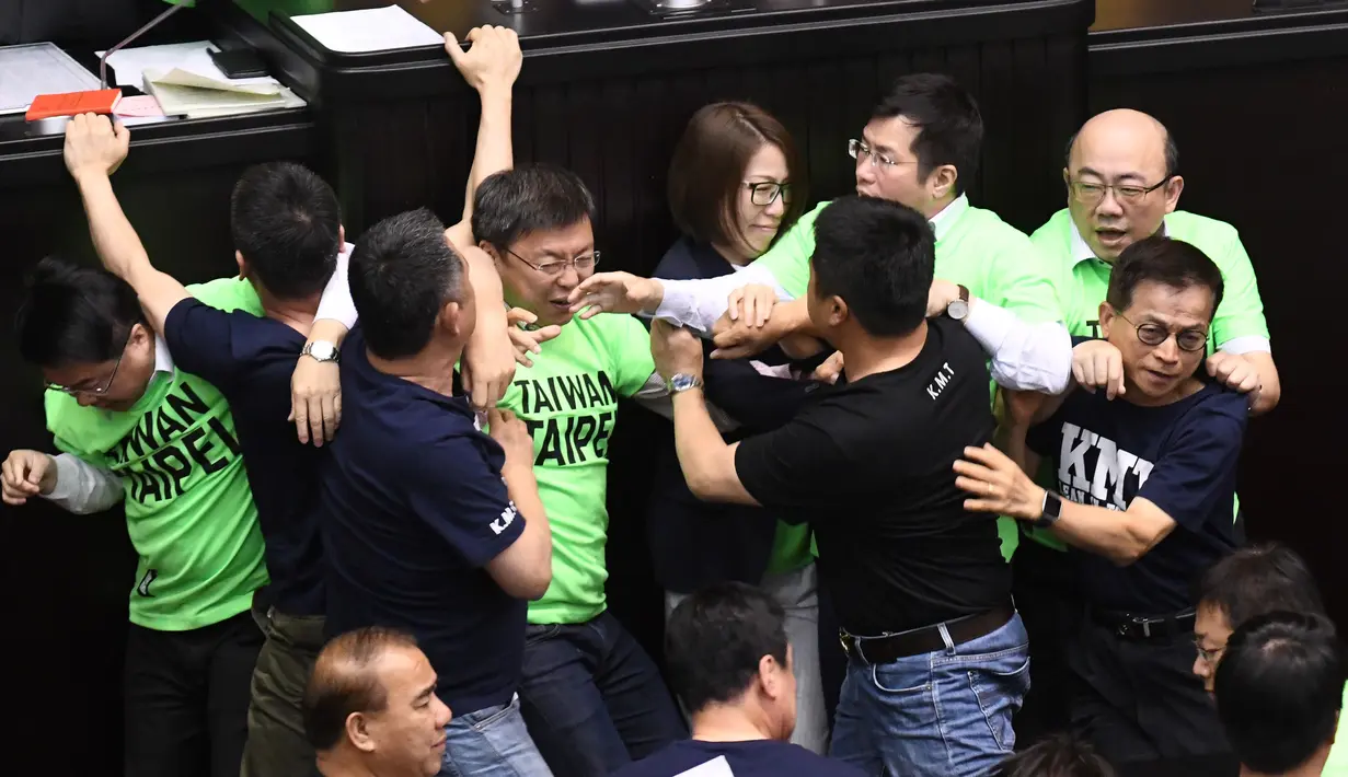 Anggota parlemen dari Partai Progresif Demokratik (DPP) terlibat bentrok dengan Kuomintang (KMT) saat melakukan protes di Parlemen di Taipei (20/4). (AFP Photo/Sam Yeh)