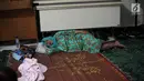 Seorang pengungsi wanita yang rumahnya terendam banjir tertidur saat mengungsi di Kelurahan Kampung Melayu, Jatinegara, Jakarta Timur, Rabu (7/2). Warga tidur hanya beralaskan tikar dan berselimut kain tipis. (Liputan6.com/Arya Manggala)