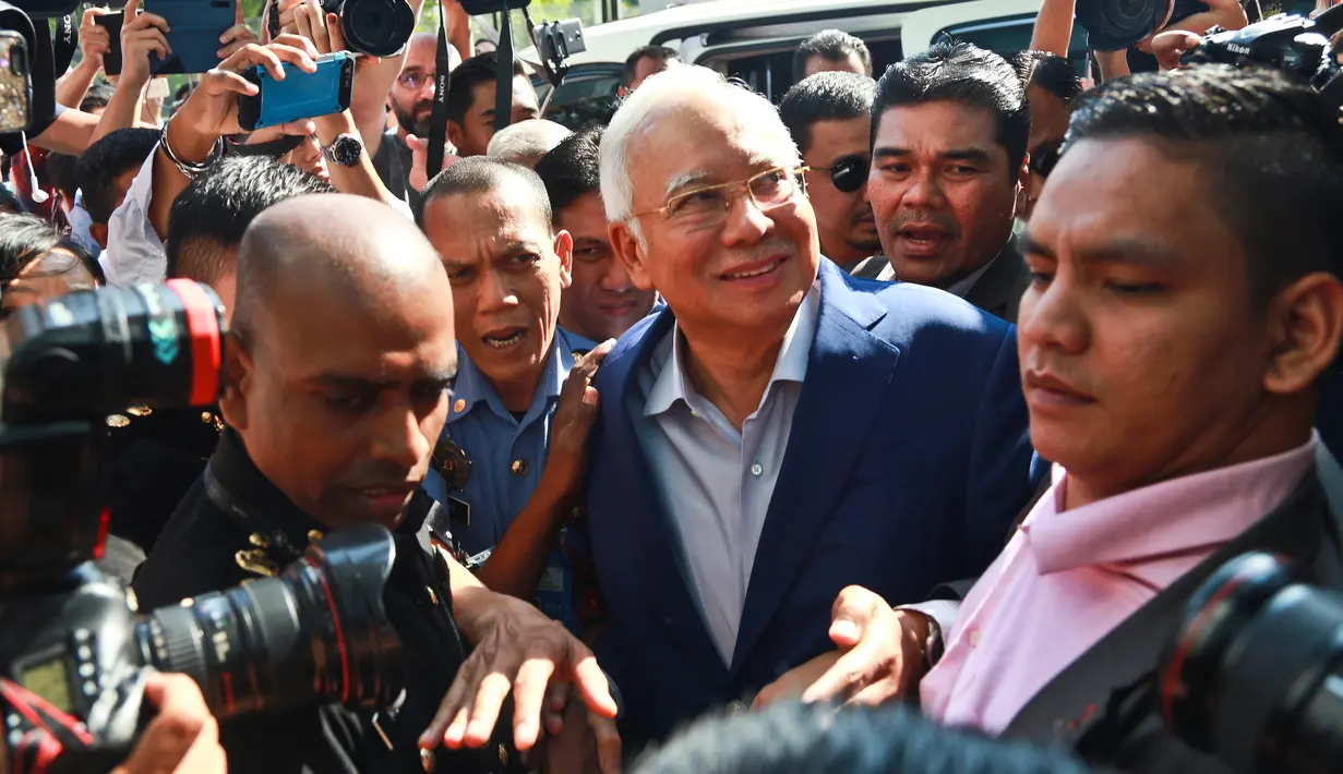 Mantan Perdana Menteri Najib Razak tiba di kantor Komisi Anti-Korupsi Malaysia (MACC) untuk menjalani pemeriksaan di Putrajaya, Selasa (22/5). Tersenyum santai, Najib Razak memasuki gedung MACC dengan pengawalan ketat petugas keamanan. (AP/Sadiq Asyraf)