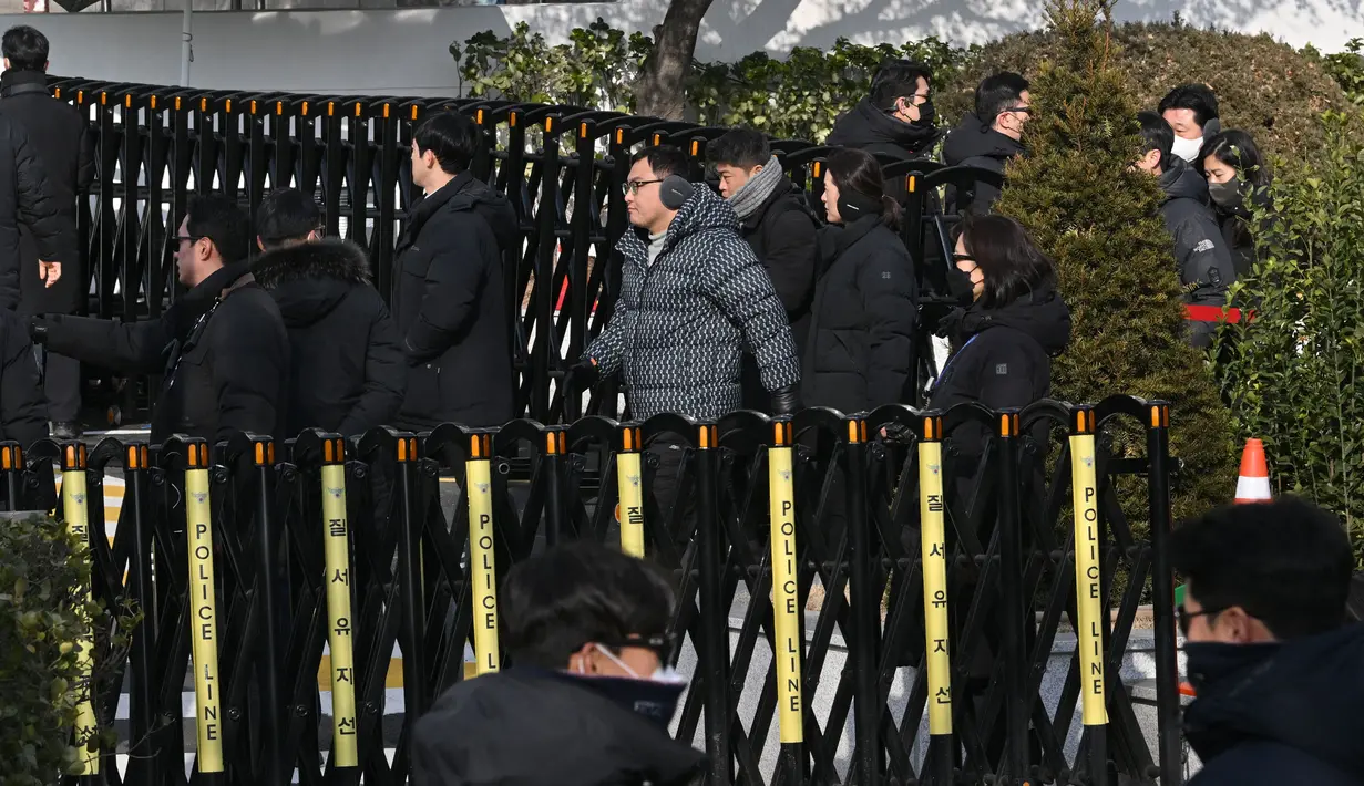 Penyidik yang didampingi personel kepolisian itu dihalangi oleh unit militer yang berjaga serta pengacara Yoon di kediaman presiden. (JUNG Yeon-je/AFP)