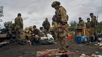 Seorang tentara Ukraina berdiri di atas bendera Rusia di Izium, wilayah Kharkiv, Ukraina, 13 September 2022. Pasukan Rusia tampak meninggalkan Kota Izium dan Svatove di Luhansk usai pasukan Ukraina memulai serangan baru ke arah timur melalui Kharkiv. (AP Photo/Kostiantyn Liberov)