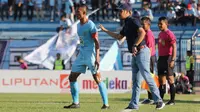 Pelatih Persela Lamongan, Nilmaizar, tengah memberikan instruksi kepada kapten Persela, Eky Taufik, dalam sebuah pertandingan Liga 1 2019. (Bola.com/Aditya Wany)