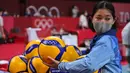 Seorang relawan menata bola selama babak penyisihan bola voli putra Olimpiade Tokyo 2020 antara Kanada dan Iran di Ariake Arena pada 28 Juli 2021. Relawan atau volunteer merupakan salah satu kunci suksesnya suatu perhelatan, tak terkecuali Olimpiade Tokyo 2020 ini. (ANDREJ ISAKOVIC/AFP)