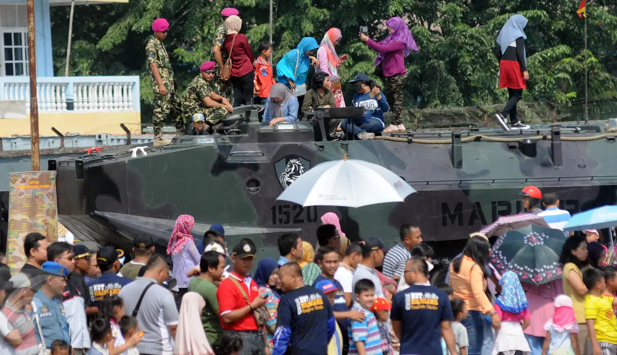 Warga menaiki tank saat Open Day Kolinlamil di Tanjung Priok, Jakarta, Minggu (24/7). Warga sekitar menyambut antusias acara HUT KOLINLAMIL 1 Juli 2016 yang Ke-55. (Liputan6.com/Helmi Afandi)
