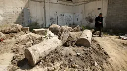 Seorang pria berjalan melewati reruntuhan kuno yang dipercaya oleh arkeolog merupakan bagian dari gereja Bizantium yang berusia sekitar 1.500 tahun lalu, yang ditemukan di kota Gaza, Senin (4/4/2016). (REUTERS/Mohammed Salem)