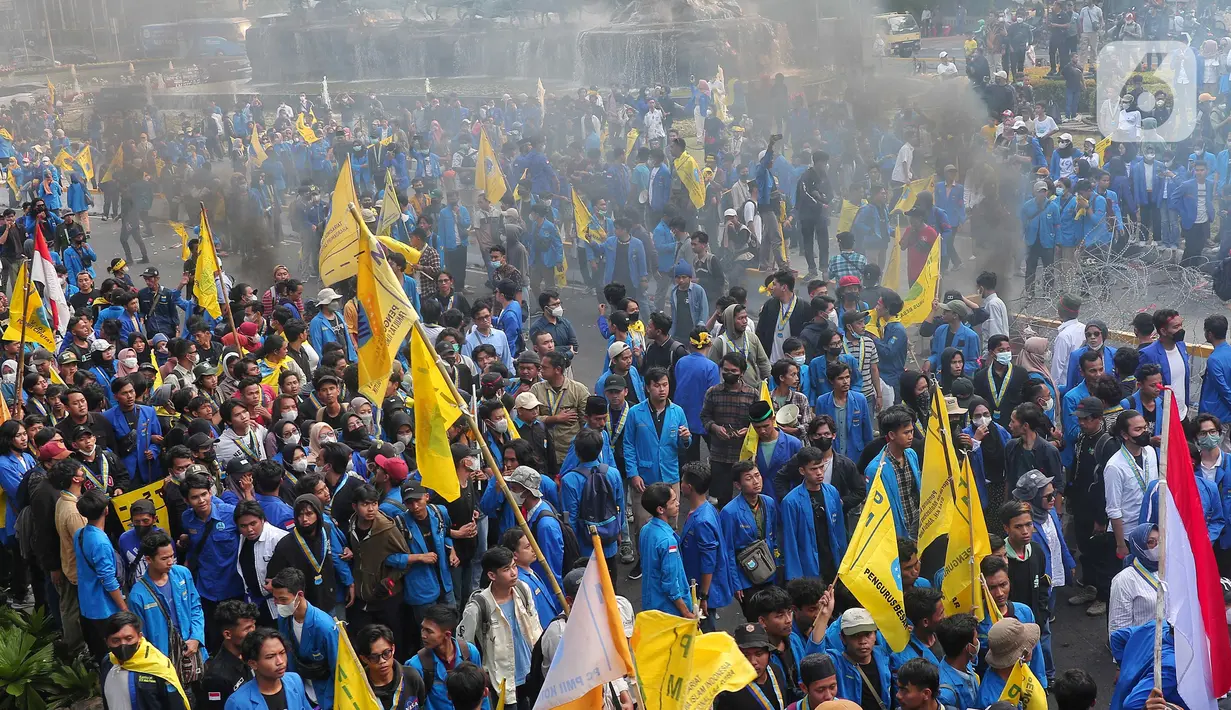 Dalam kerumunan massa terlihat asap hitam bekas ban terbakar saat aksi unjuk rasa atau demo BBM naik di kawasan Patung Kuda, Jakarta, Senin (5/9/2022). Kenaikan harga BBM ini kemudian memicu reaksi publik secara luas. Mahasiswa kemudian berdemo dan dijadwalkan massa buruh juga akan turun ke jalan. (Liputan6.com/Angga Yuniar)