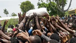 Warga berebut sekantong beras yang disumbangkan di dekat sebuah truk yang penuh dengan persediaan bantuan di Vye Terre, Haiti, Jumat (20/8/2021).  Bantuan swasta dan kiriman dari pemerintah AS dan lainnya tiba di semenanjung barat daya negara itu. dilanda. (AP Photo/Fernando Llano)