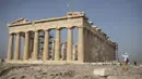 Seorang pria mengambil gambar Kuil Parthenon di Bukit Acropolis, Athena, Yunani, Senin (18/5/2020). Yunani kembali membuka kota kuno Acropolis serta situs-situs lainnya setelah dua bulan ditutup selama lockdown akibat pandemi virus corona COVID-19. (AP Photo/Petros Giannakouris)