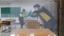 Petugas mendisinfeksi pembatas plastik pada meja untuk ujian masuk perguruan tinggi, Seoul, Korea Selatan, Selasa (1/12/2020). Sekitar 490.000 siswa lulusan sekolah menengah atas di Korea Selatan akan menjalani Tes Kemampuan Skolastik Perguruan Tinggi pada 3 Desember 2020. (AP Photo/Ahn Young-joon)