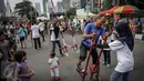 Seorang warga mencoba bermain Egrang saat demo ragam olahraga rekreasi TAFISA Games 2016 di kawasan Car Free Day Thamrin, Jakarta, Minggu (25/9). Kegiatan itu mengajak masyarakat untuk kembali mengenal permainan tradisional. (Liputan6.com/Faizal Fanani)