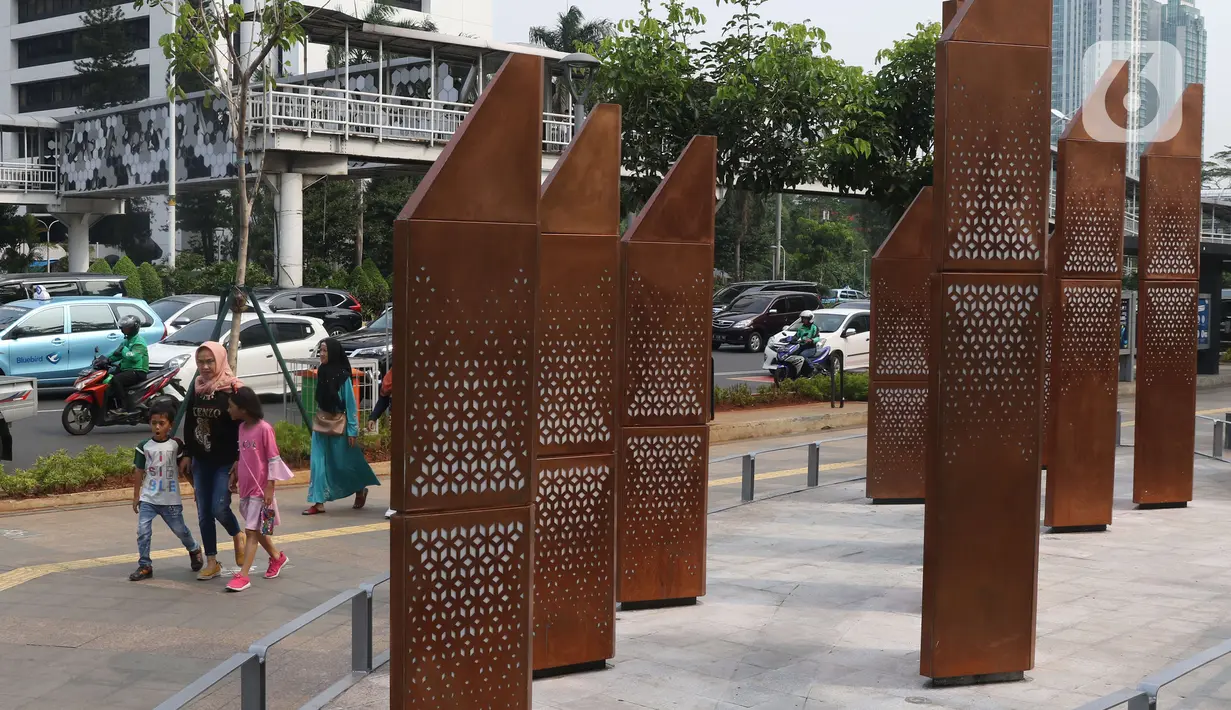 Warga melintasi sebuah instalasi di kawasan Sudirman, Jakarta, Sabtu (23/11/2019). Pemprov DKI Jakarta gencar membangun dan menyediakan ruang publik bagi masyarakat, baik untuk pegawai kantoran hingga mahasiswa, yang berlalu lalang agar bebas menikmati ruang ini. (Liputan6.com/Angga Yuniar)