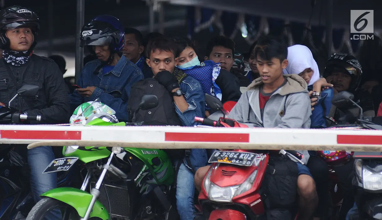 Sejumlah pemudik di atas motor saat menanti waktu masuk kapal penyereberangan di Dermaga 6 Pelabuhan Merak, Banten, Kamis (22/6). Dini hari, ribuan pemudik bermotor menyeberang dari Merak menuju Bakauheni, Lampung. (Liputan6.com/Helmi Fithriansyah)