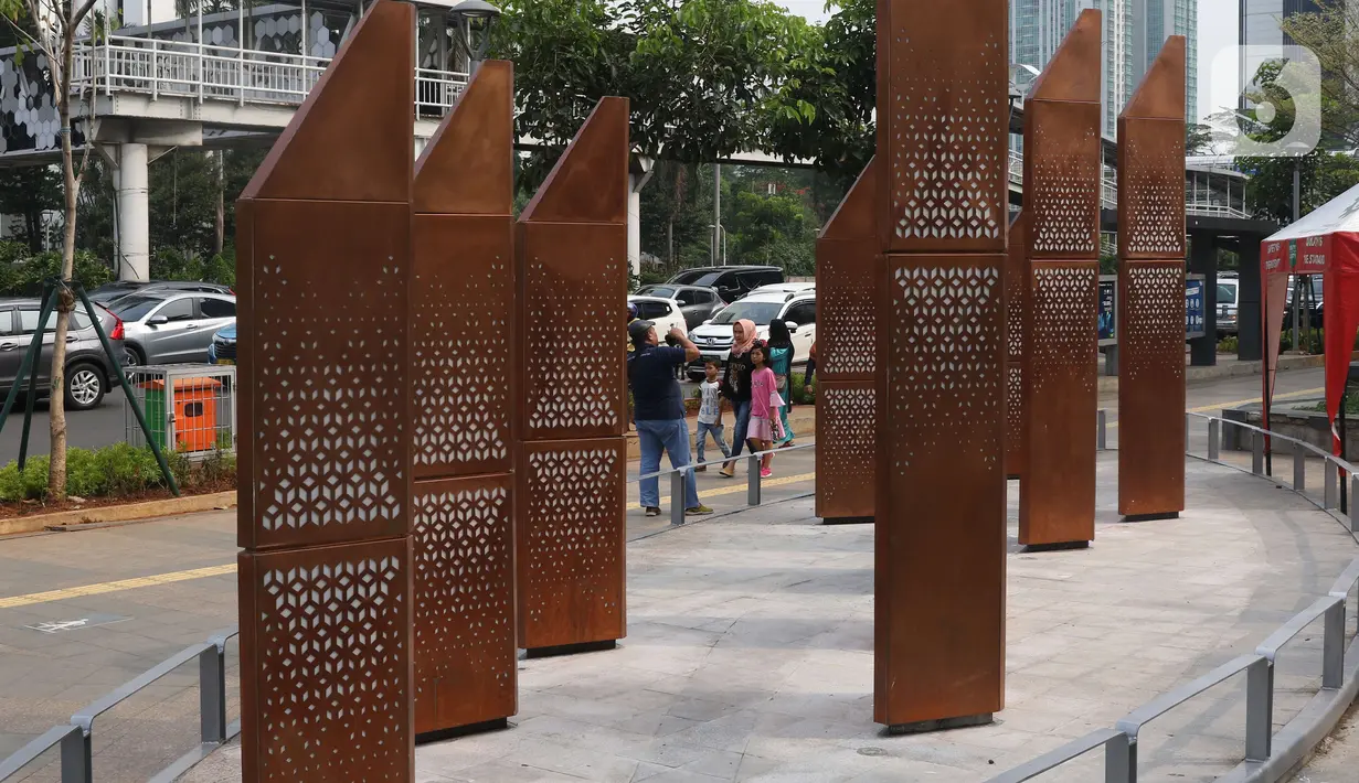 Warga melintasi sebuah instalasi di kawasan Sudirman, Jakarta, Sabtu (23/11/2019). Pemprov DKI Jakarta gencar membangun dan menyediakan ruang publik bagi masyarakat, baik untuk pegawai kantoran hingga mahasiswa, yang berlalu lalang agar bebas menikmati ruang ini. (Liputan6.com/Angga Yuniar)