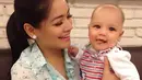 Saat menggendong baby Kai, Titi lebih sering terlihat menguncir rambutnya seperti ekor kuda. Gaya busananya juga sederhana, termasuk riasan di wajahnya yang juga tidak berlebihan. (Instagram/titi_kamall)