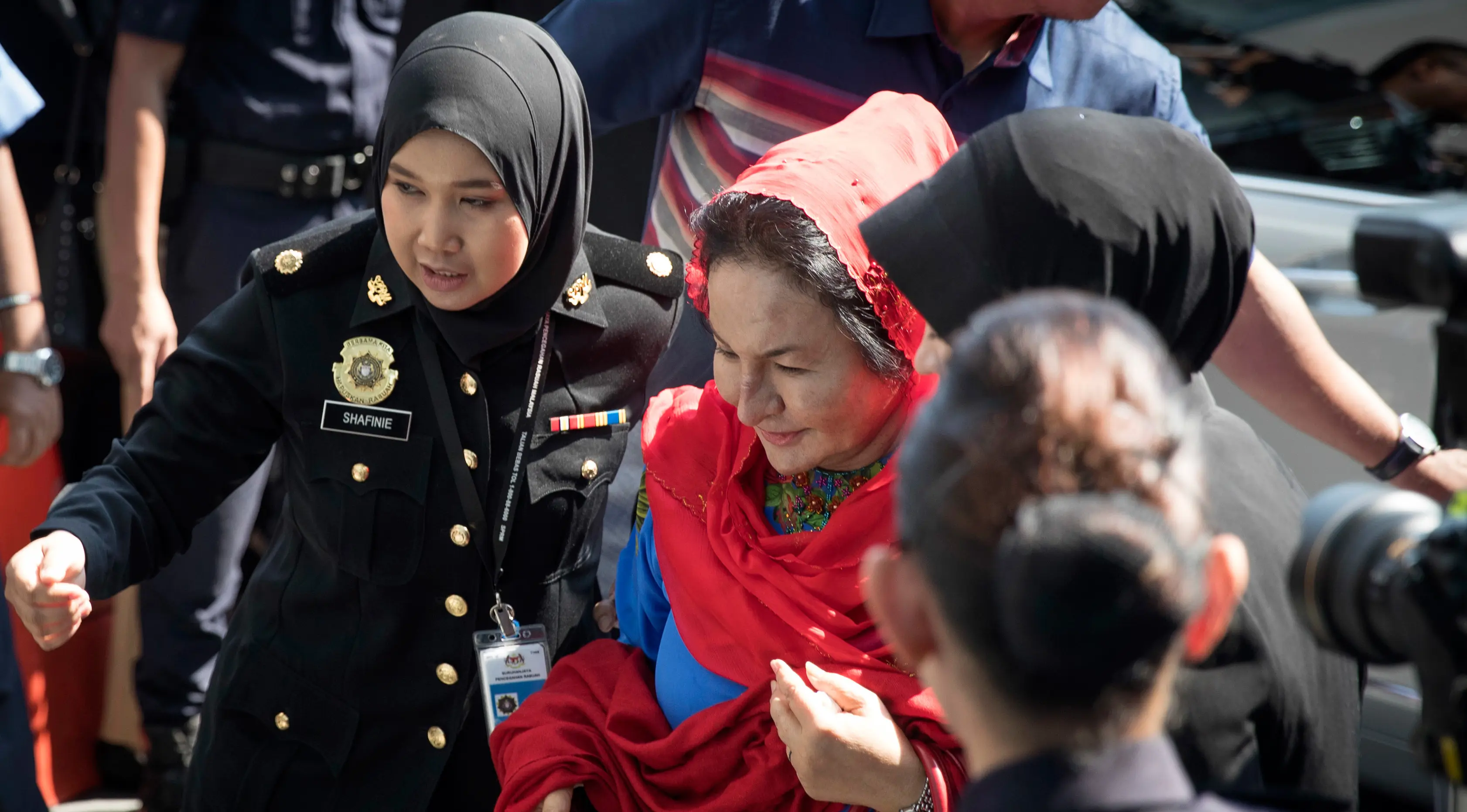 Istri mantan Perdana Menteri Malaysia Najib Razak, Rosmah Mansor dikawal petugas saat memenuhi panggilan Komisi Antikorupsi Malaysia (MACC) di Putrajaya, Selasa (6/5). Rosmah tampak tenang turun dari mobil dan berjalan ke kantor MACC. (AP/Vincent Thian)