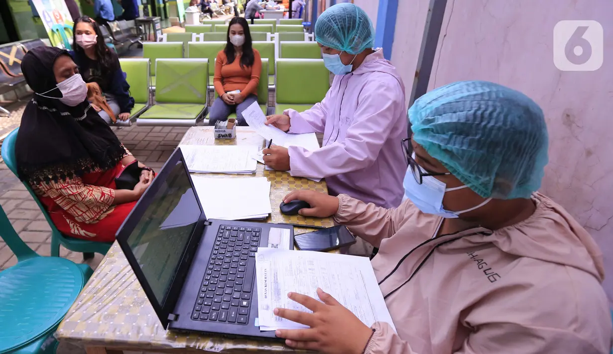 Tenaga kesehatan melakukan pendataan saat melakukan tes PCR COVID-19 kepada warga di Puskesmas Cipadu, Tangerang, Banten, Selasa (22/2/2022). Kasus COVID-19 di Jawa-Bali perlahan-lahan menurun. (Liputan6.com/Angga Yuniar)